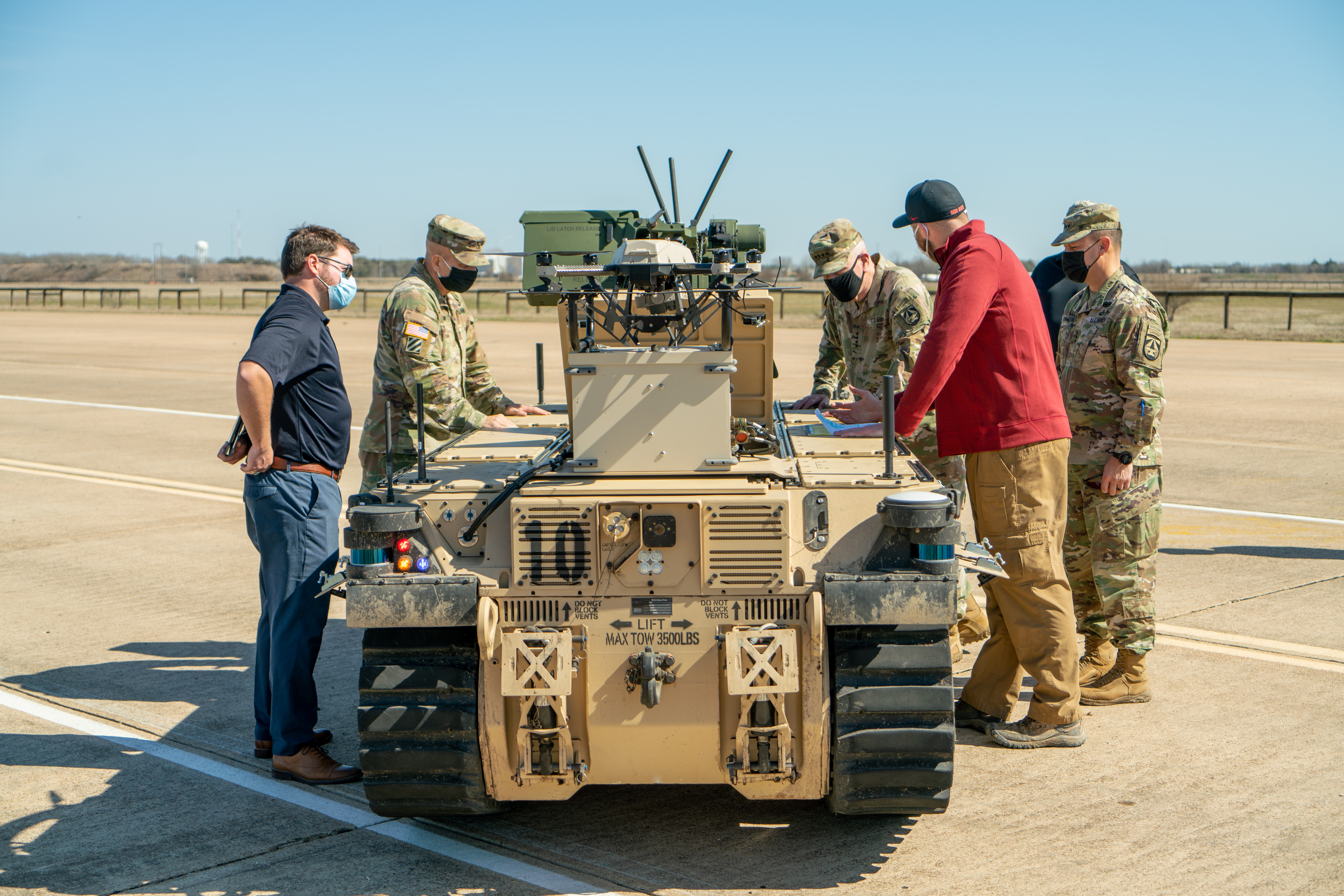 Maj. Gen. Ross Coffman, NGCV director, Gen. John Murray, AFC commanding general, and Lt. Gen. Scott McKean, AFC deputy commanding general, talk to Greg Colvin, RCV deputy chief engineer at GVSC, about the RCV-Light prototype vehicle being tested at the IPG on RELLIS Campus in February. 