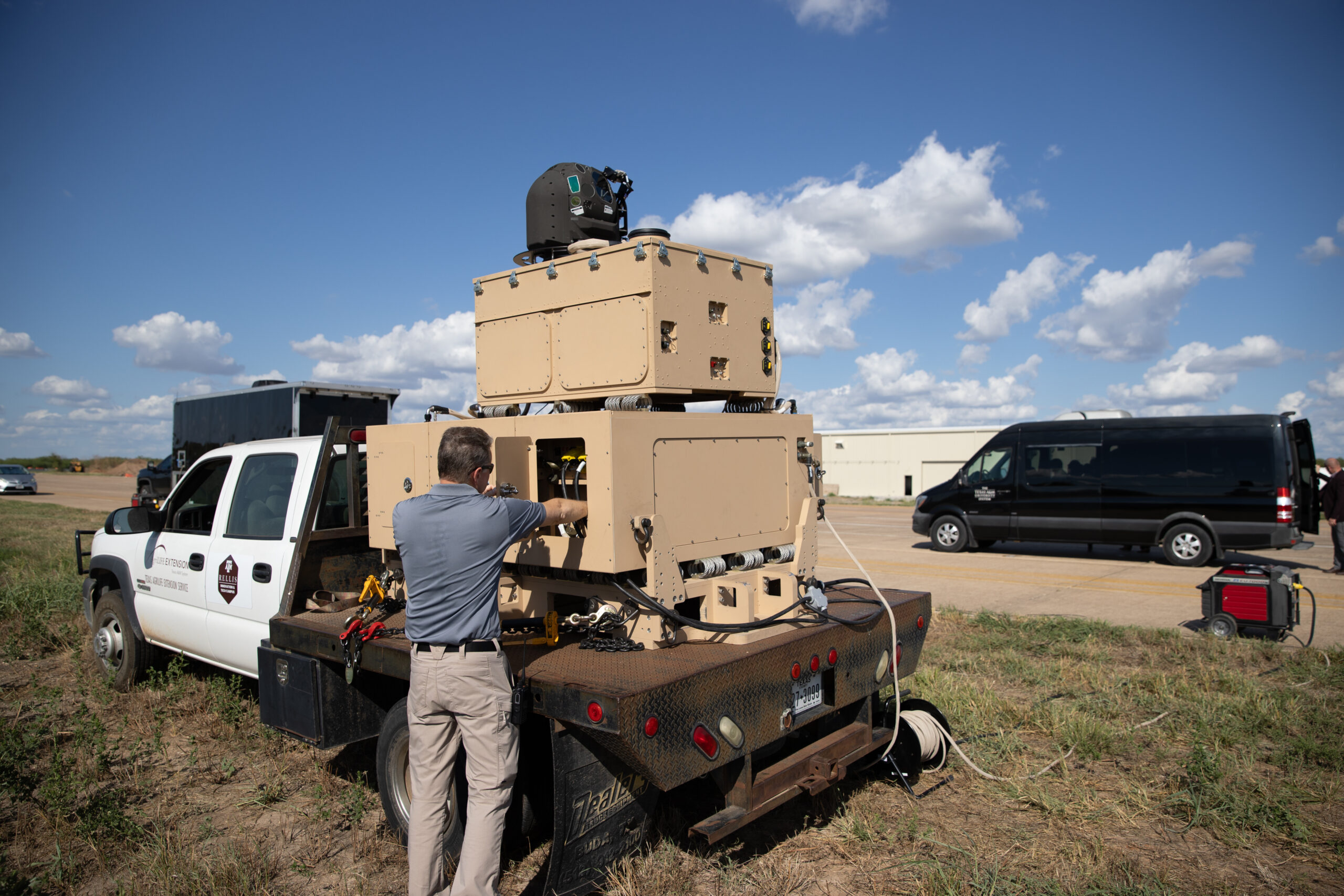 A Raytheon High Energy Laser system with a man working on it at the Texas A&M RELLIS campus.